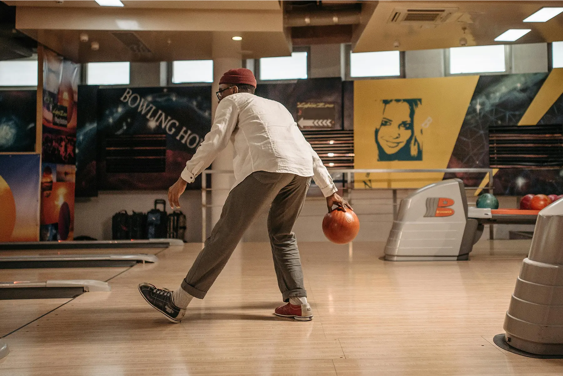 Bowl a thon fundraiser featuring a participant rolling a bowling ball down the lane, aiming for a strike.