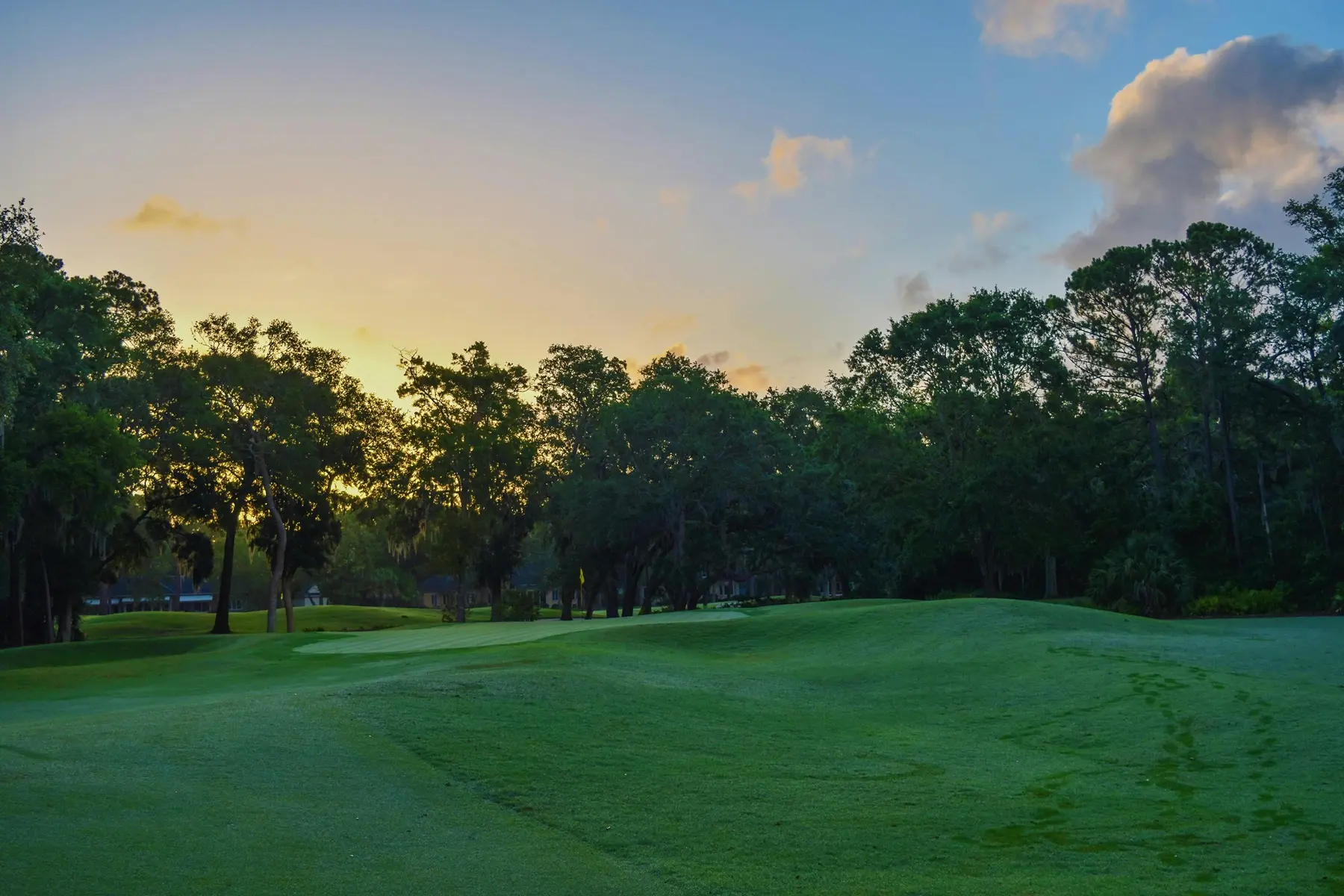 Scenic view of a golf course on golf outing day with neatly trimmed fairways and clear skies.