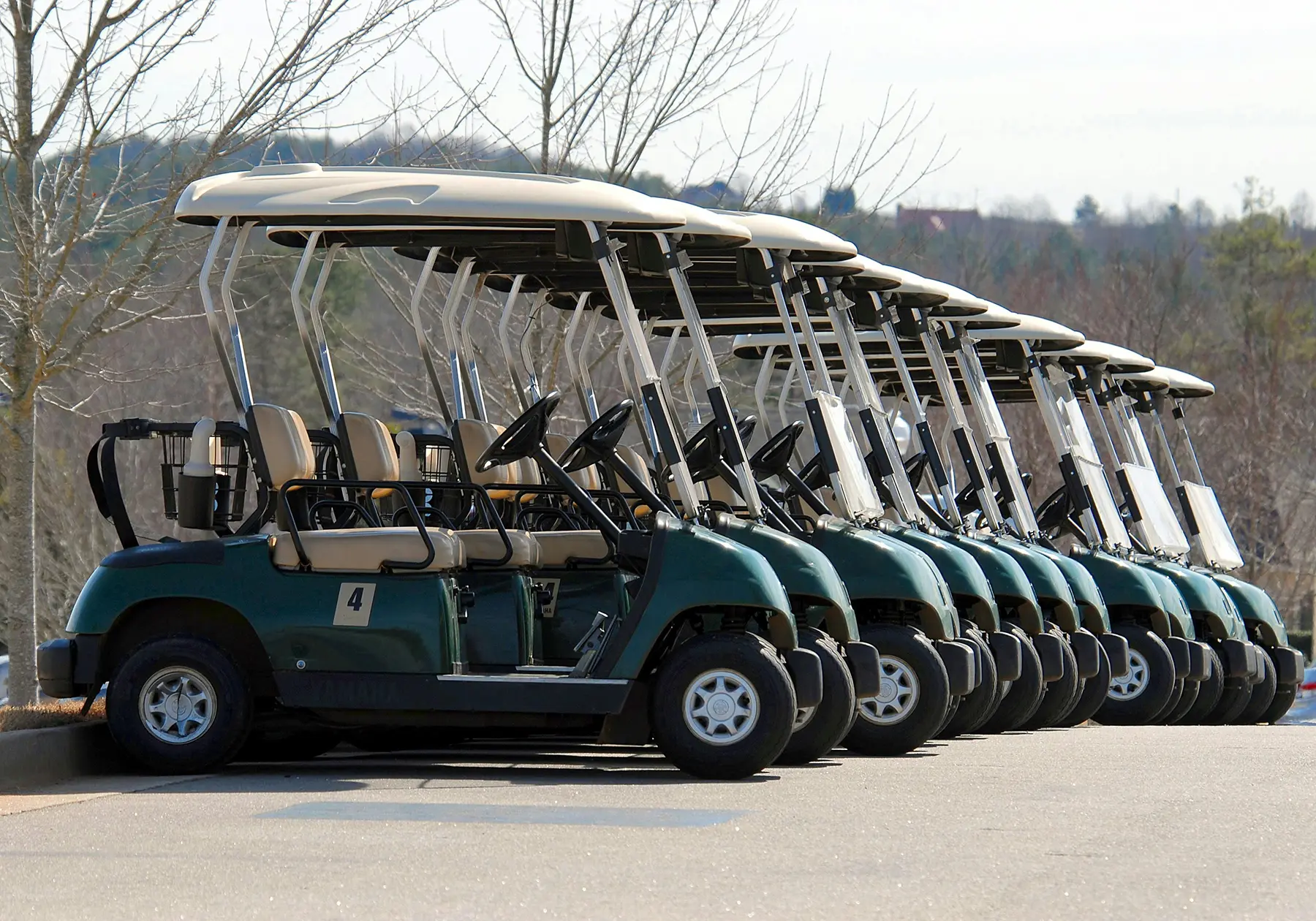 Row of golf carts lined up and ready for golfers on golf outing day.