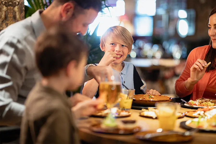A kid eating during a great fundraiser idea, restaurant night.