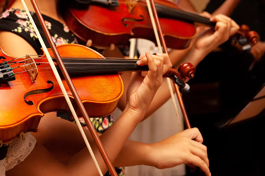 Middle schoolers practicing on the violin during an orchestra fundraiser.