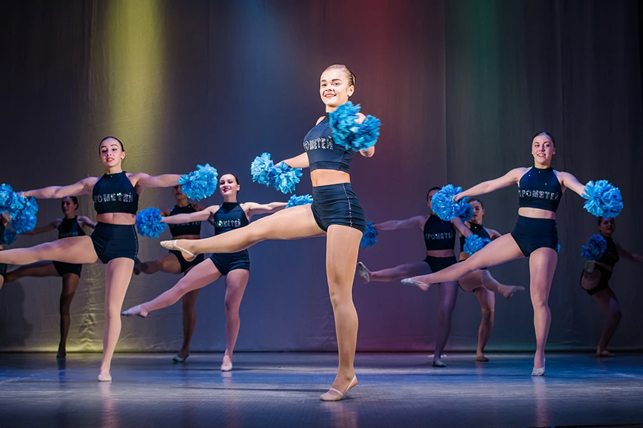 Dancers perform on a school stage during a talent show, a performing arts fundraising idea.