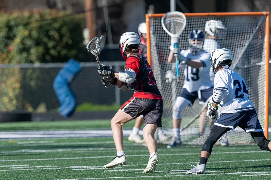 Lacrosse players in uniforms bought through lacrosse fundraising ideas like apparel sales.
