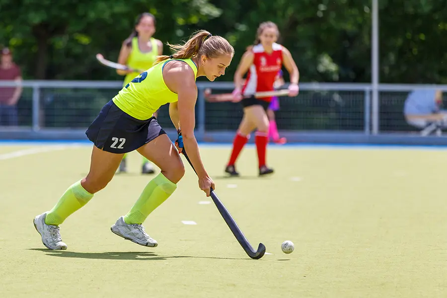 Field hockey player helping with fundraising for hockey through a hockey clinic.