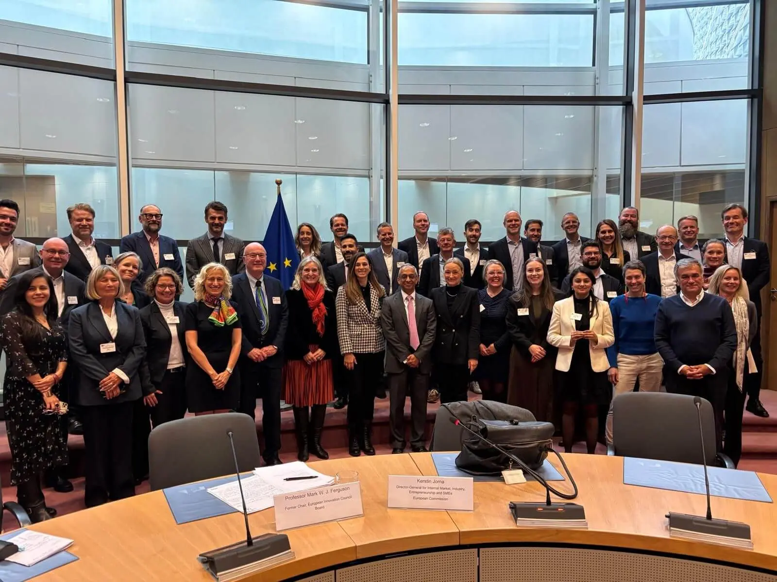 A group of people standing in front of a table.