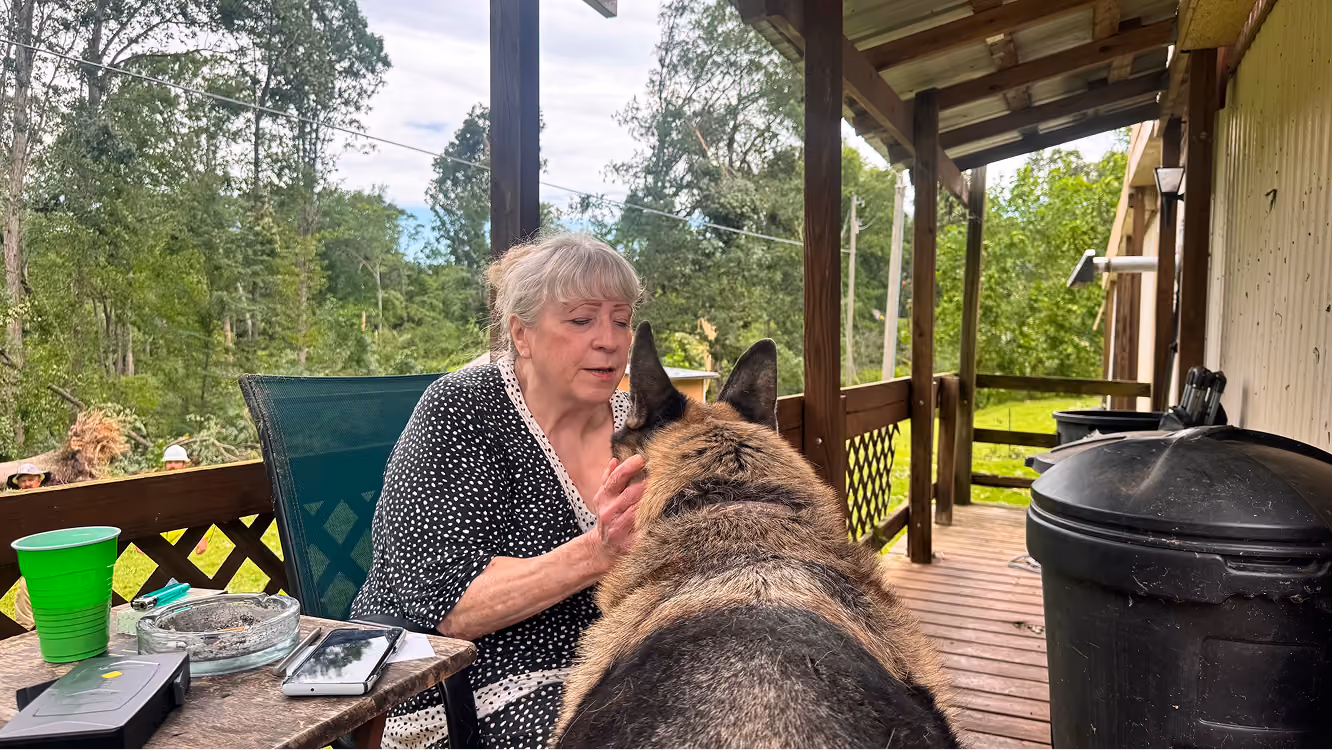 Sue McNeive and her German shepherd, Choco, sit on her porch on June 18 on Buskirk Road in rural Gosport. Choco sat with McNeive during the tornado that damaged her house and yard the night before. CHLOE ODEN | THE OWEN NEWS
