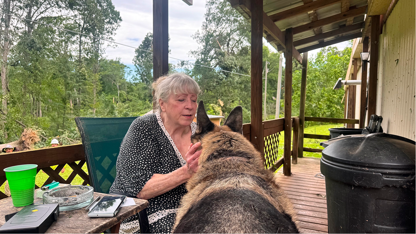 Sue McNeive and her German shepherd, Choco, sit on her porch on June 18 on Buskirk Road in rural Gosport. Choco sat with McNeive during the tornado that damaged her house and yard the night before. CHLOE ODEN | THE OWEN NEWS