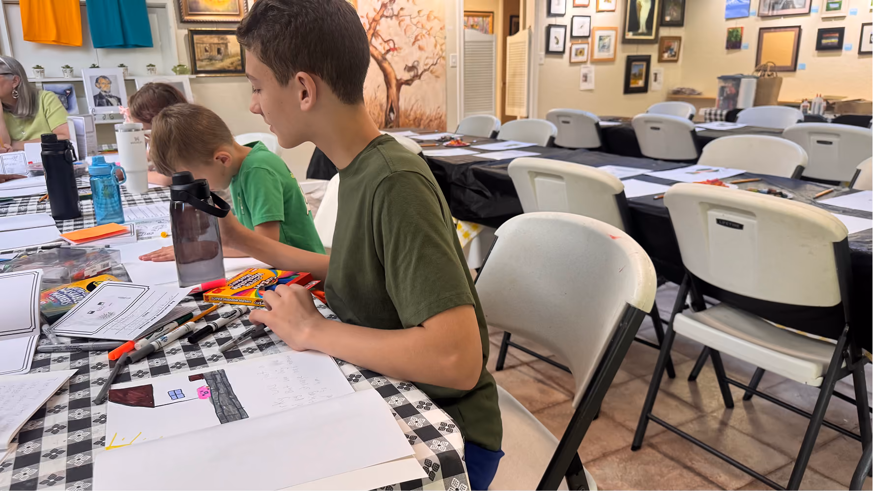 Lucas Smeltzer looks toward another camp participant's work of art on June 11, 2026, at the Owen County Art Guild. Smeltzer's children's book was about Porky the pig.
