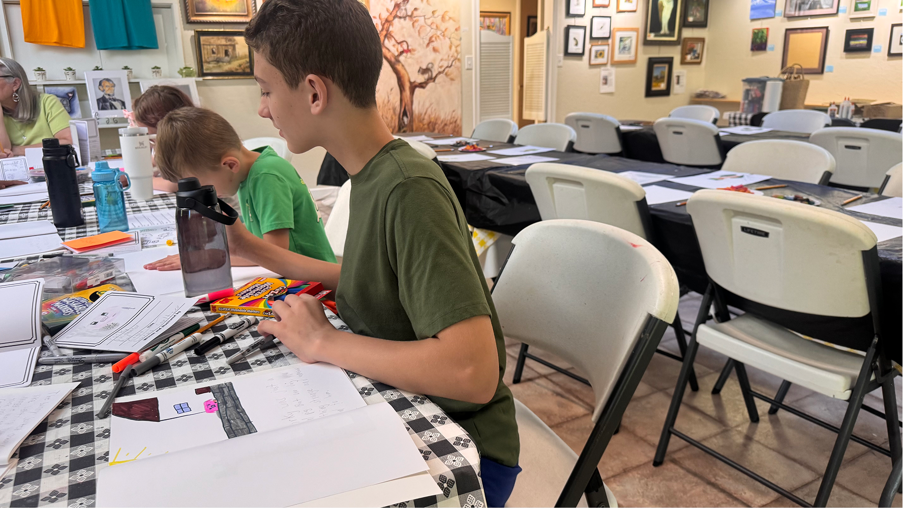 Lucas Smeltzer looks toward another camp participant's work of art on June 11, 2026, at the Owen County Art Guild. Smeltzer's children's book was about Porky the pig.