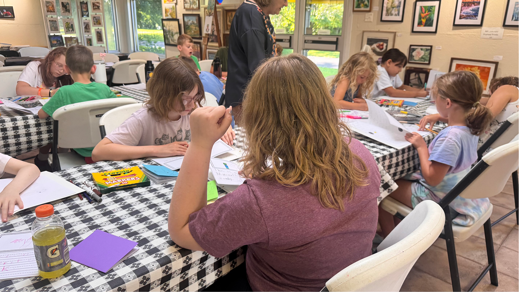 Felicity Arthur (back) and Amelia Borders (front) work on their children's books on June 11 at the Owen County Art Guild. Creating children's books was a new addition to the program this year.