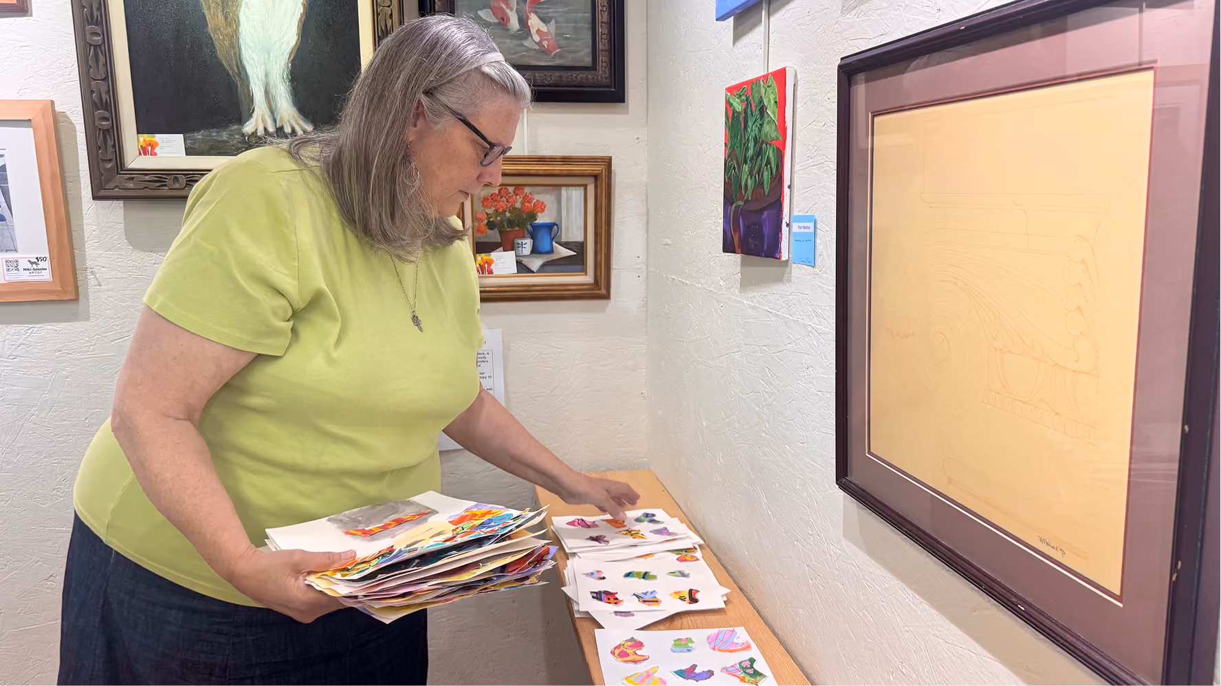 Linda Barrett collects campers' works of art from a shelf on June 11 at the Owen County Art Guild. Barrett works as a volunteer at the guild.