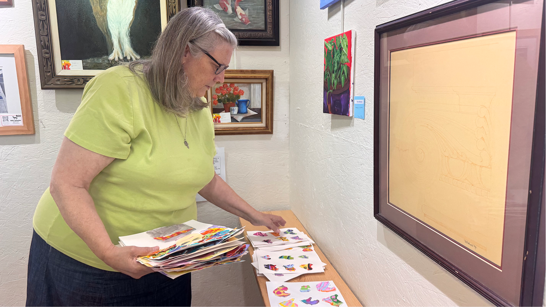 Linda Barrett collects campers' works of art from a shelf on June 11 at the Owen County Art Guild. Barrett works as a volunteer at the guild.