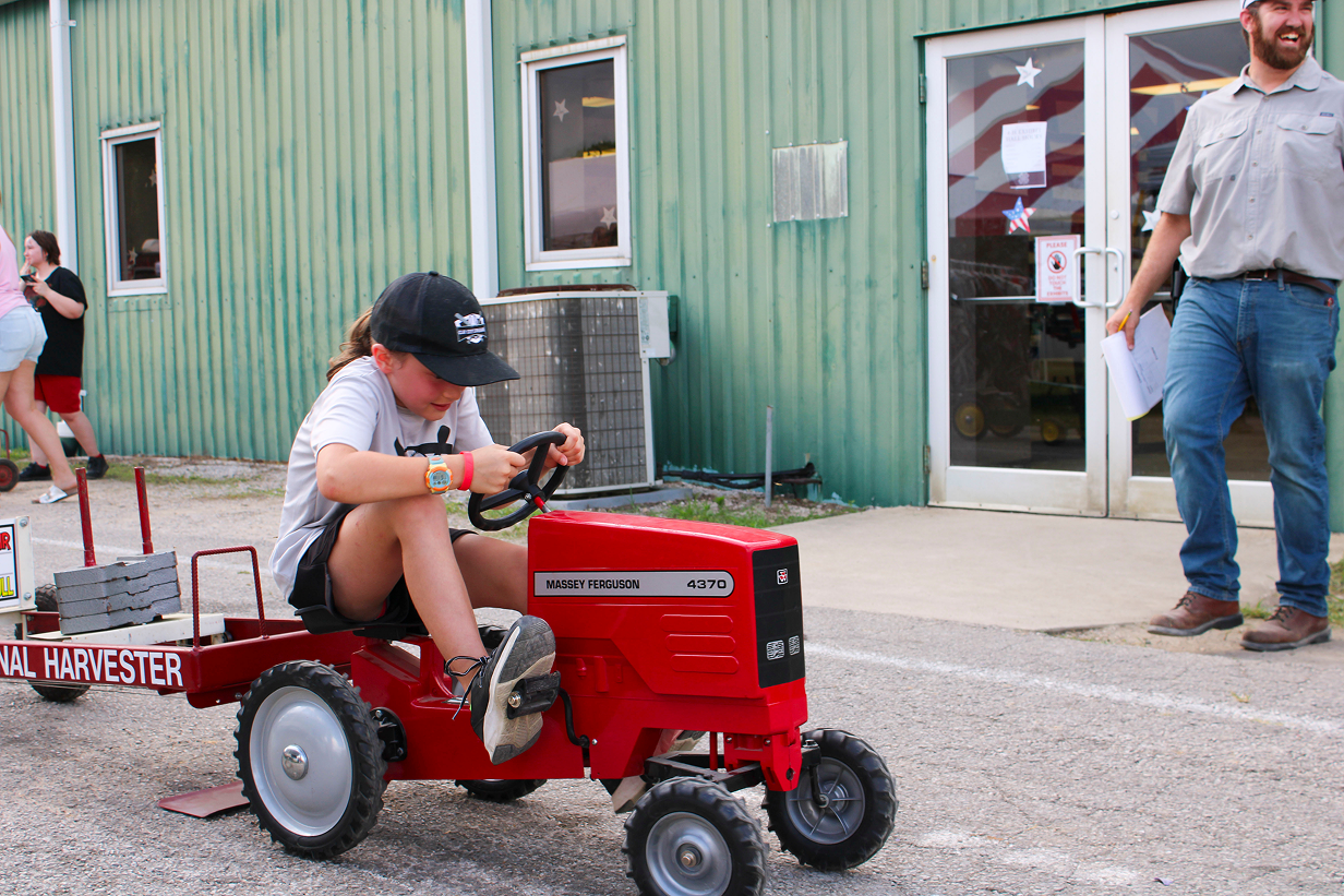Ellie Wright works to move her tractor forward in the Kiddie Tractor Pull on July 10 outside the Exhibit Hall at the Owen County Fairgrounds. CHLOE ODEN | THE OWEN NEWS