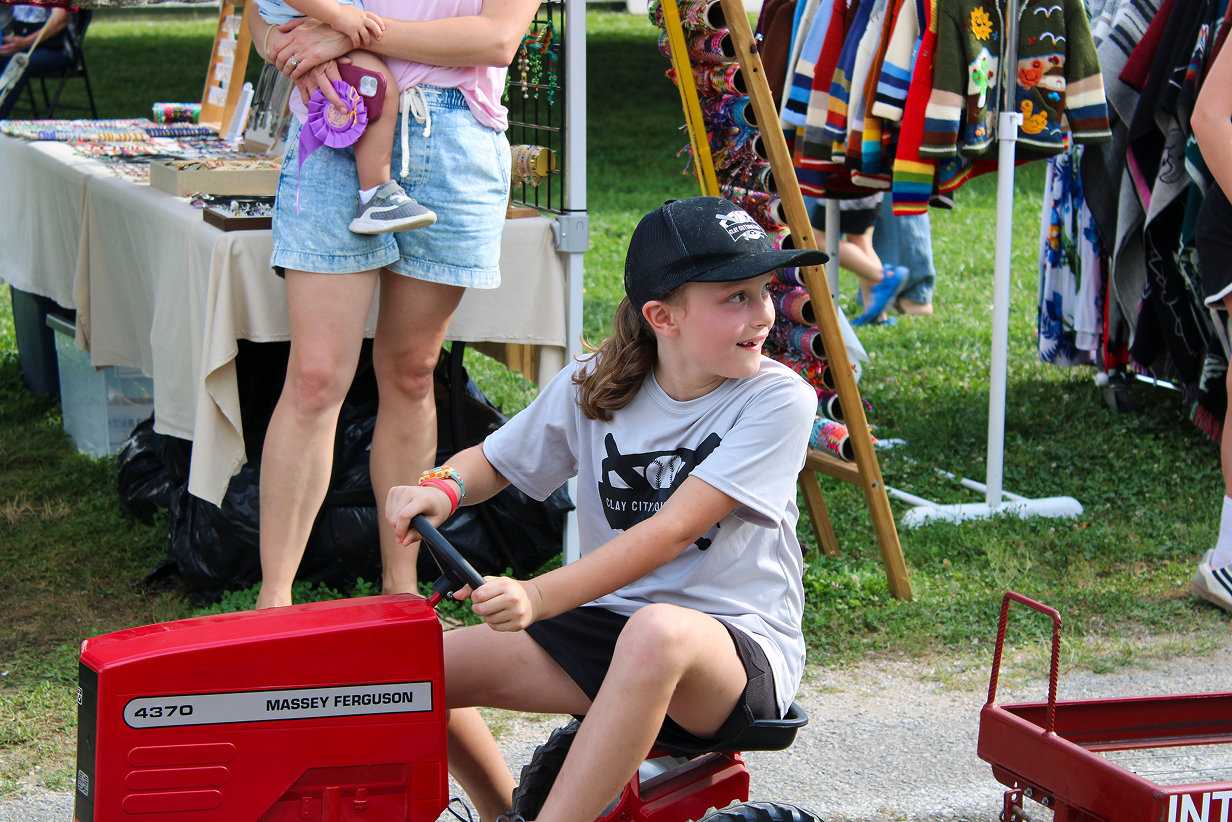 Ellie Wright looks behind her while racing in the Kiddie Tractor Pull on July 10 outside the Exhibit Hall at the Owen County Fairgrounds. CHLOE ODEN | THE OWEN NEWS