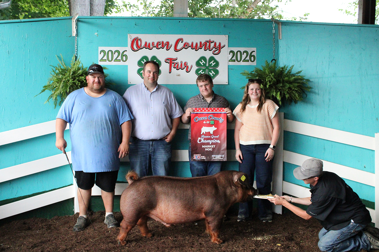 From left, Kevin Cooper stands next to Judge Andon Boocher, Reserve Grand Champion Market Hog winner Bryson Cooper and Kailee Cooper while Keagan Shively holds a plate for the pig on July 9 at the Owen County Fairgrounds. CHLOE ODEN | THE OWEN NEWS