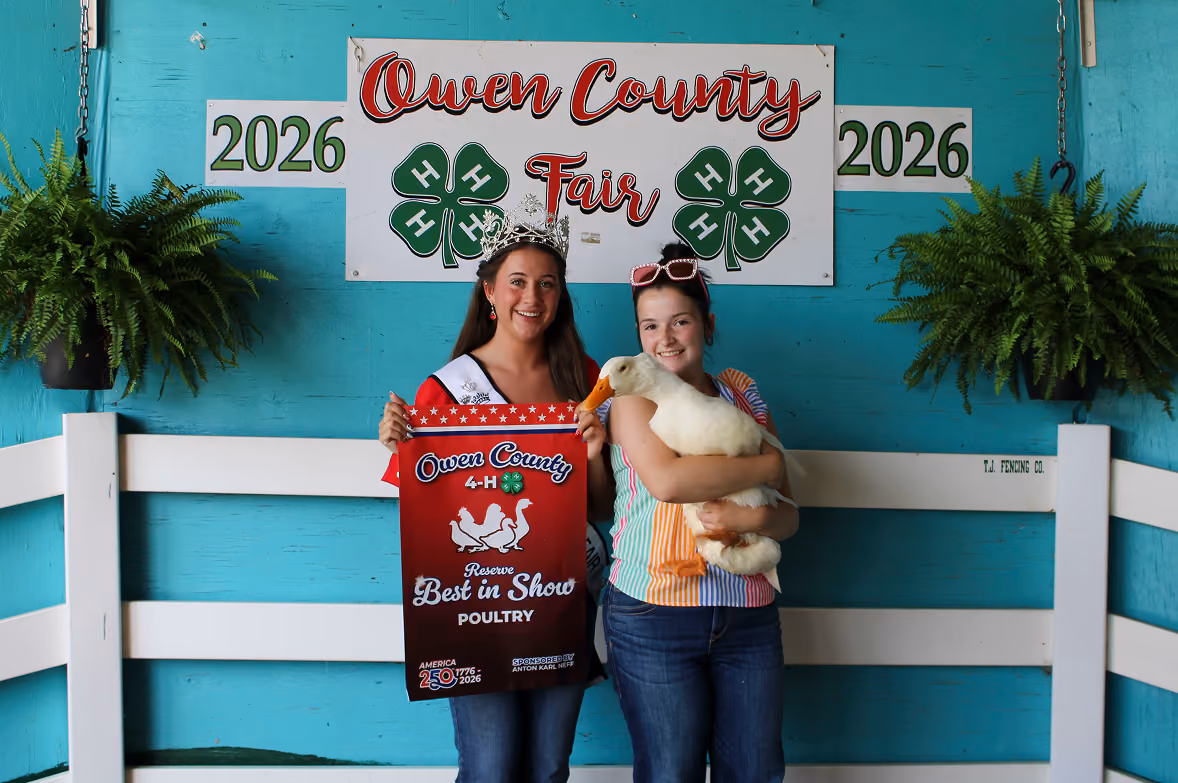 From left, 2026 Miss Owen County Makayla Hall poses next to Ily Swan, who holds her Reserve Grand Champion goose in the Poultry Show on July 8 at the Owen County Fairgrounds. CHLOE ODEN | THE OWEN NEWS