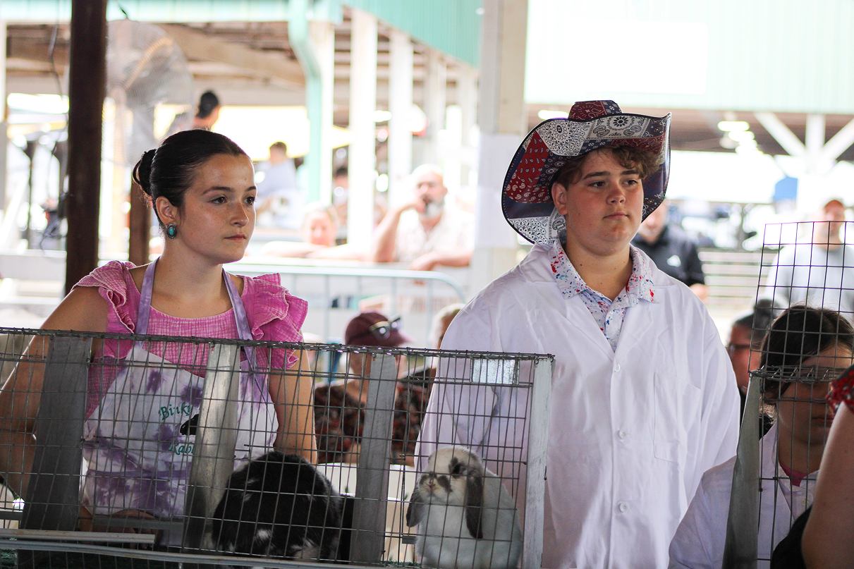 Ily Swan and Cash Weaver wait for judge Danielle Rowe to judge their rabbits on July 6 at the Owen County Fairgrounds. CHLOE ODEN | THE OWEN NEWS