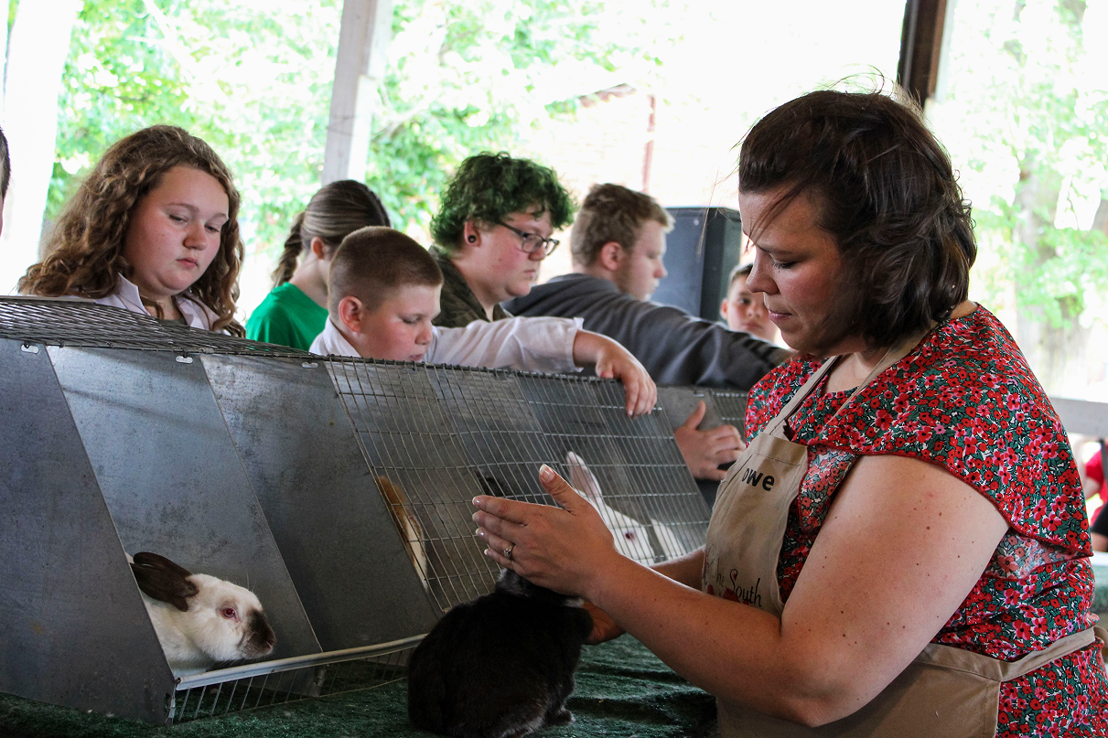 Judge Danielle Rowe assesses a rabbit during the 2026 Owen County Fair rabbit show on July 6 at the Owen County Fairgrounds. The entrants watched Rowe judge their projects. CHLOE ODEN | THE OWEN NEWS