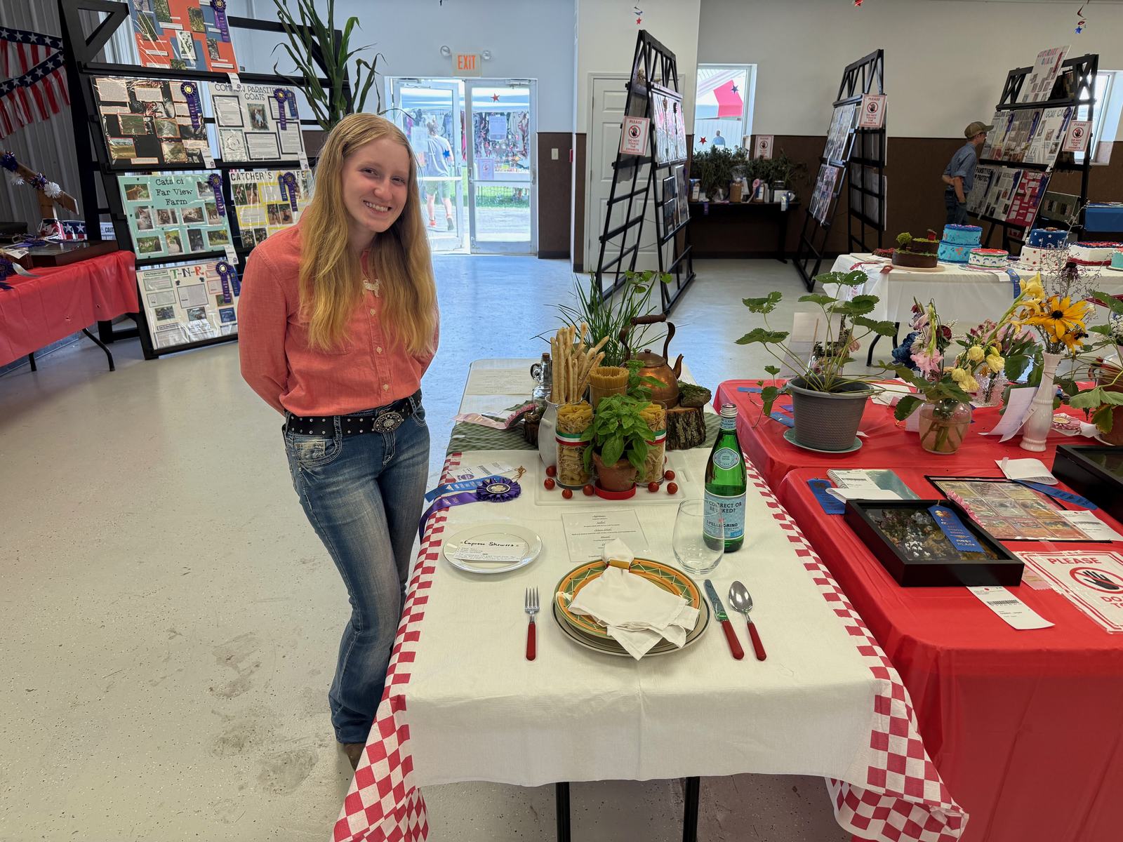 Parker Curtis poses for a photo next to the Table Presentation project that secured a Grand Champion win. NICOLE DECRISCIO | THE OWEN NEWS