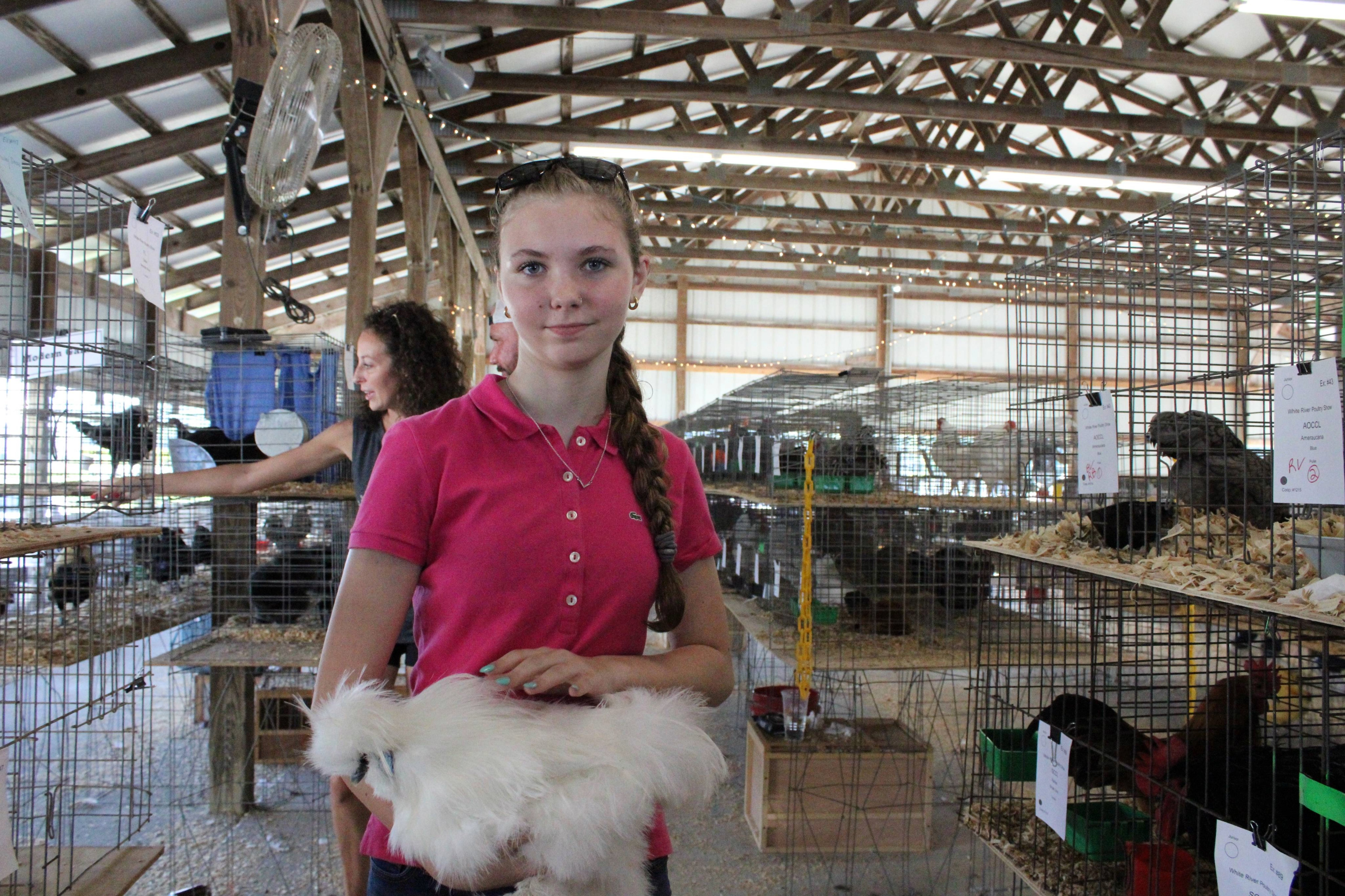 Exhibitor Bryar Warf poses with her male silkie chicken Mozzerella before the judging begins.