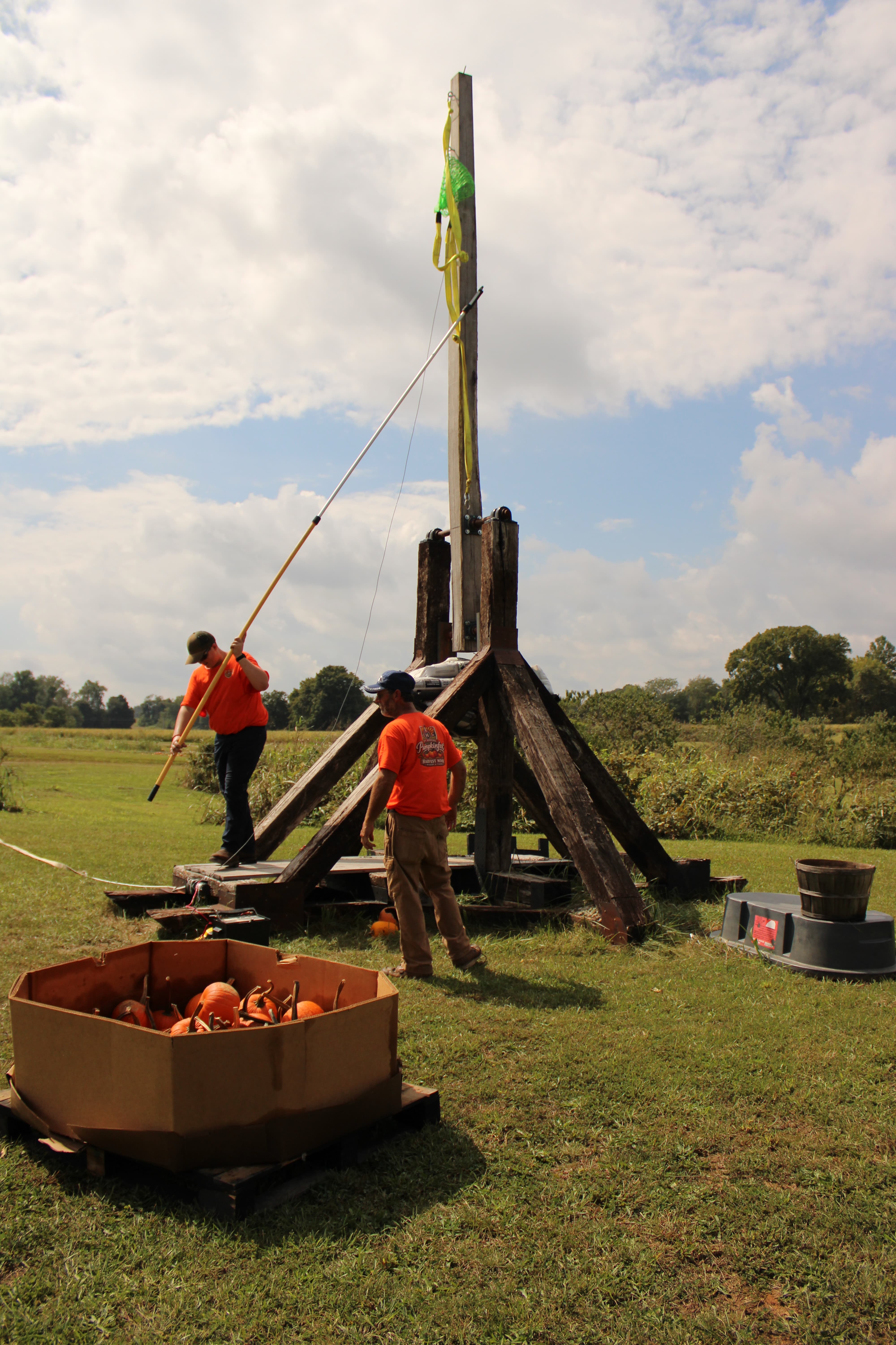 Elijah Newton and Ernie Hupp prepare the trebuchet for the pumpkin launch. Built last season in one week, the 15-foot trebuchet is a model of the 100 foot tall Warwolf, a legendary 14th century Scottish weapon capable of throwing 300lb rocks. This model will be used to launch pumpkins across a field at Harvest Moon Winery. STAFF PHOTO | THE OWEN NEWS
