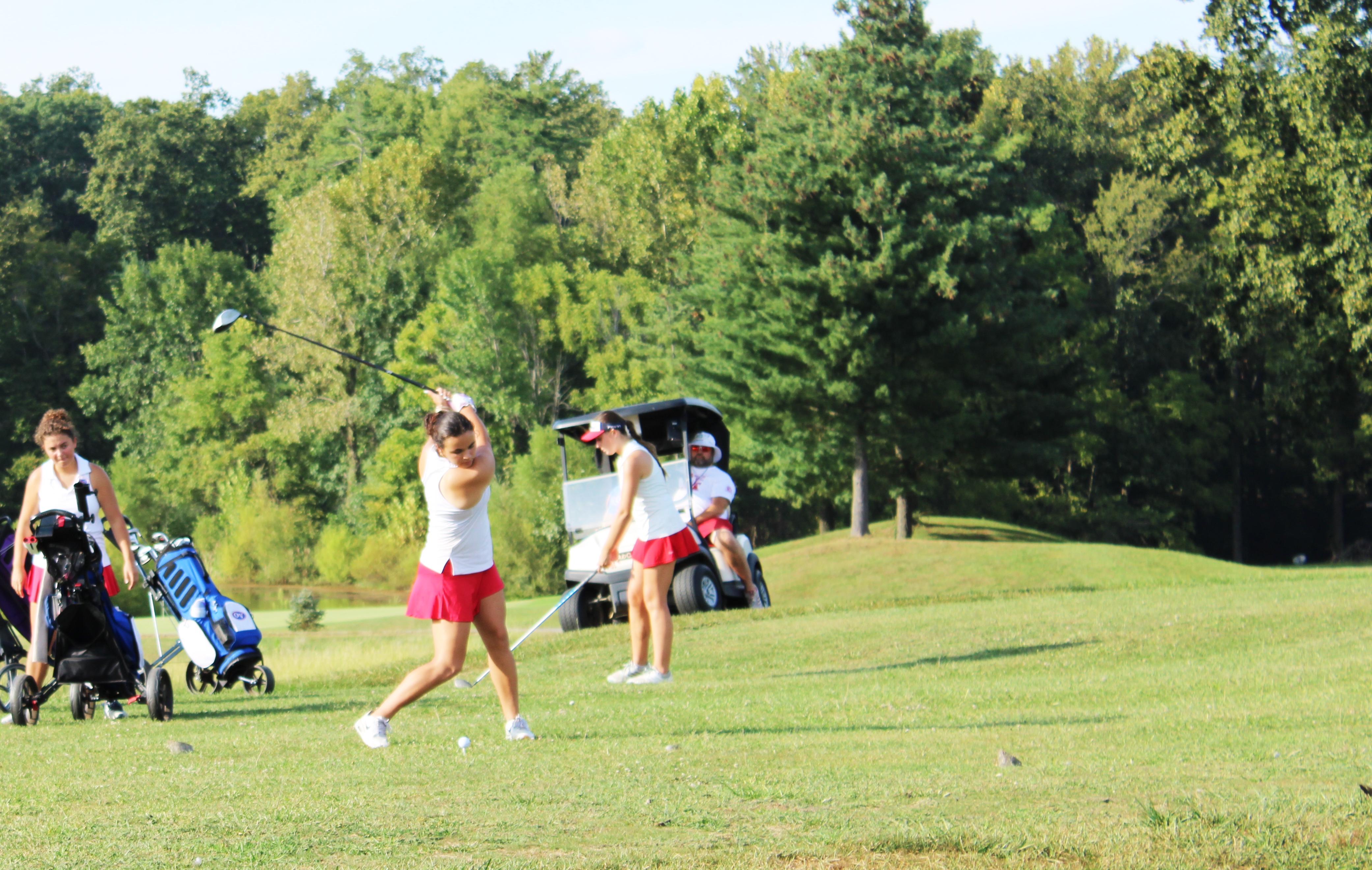 Haley Amador tees off as Makayla Hall warms up. The Patriots defeated Greencastle at Rolling Meadows on September 8. STAFF PHOTO | THE OWEN NEWS