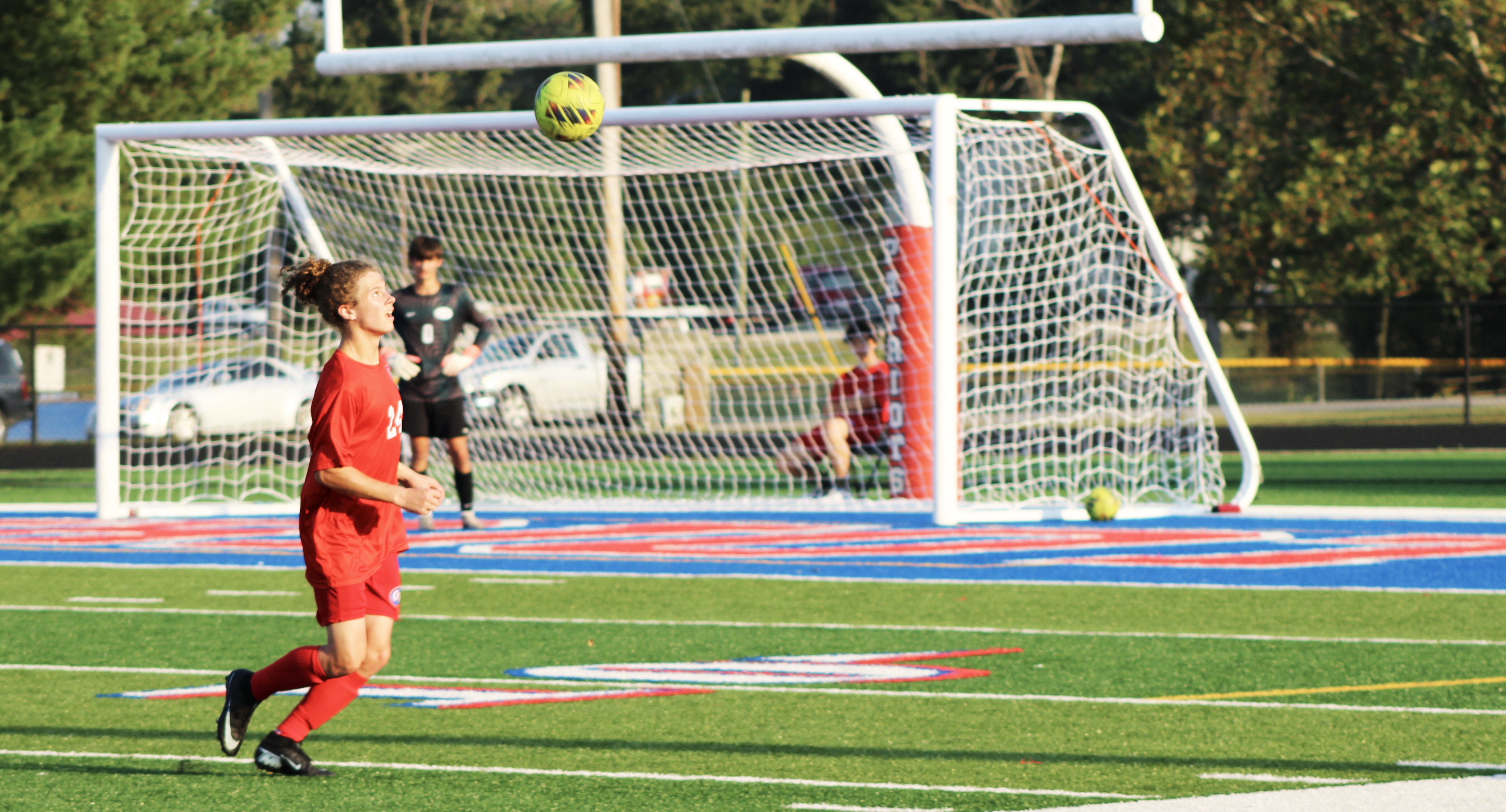 Senior Kayden Spencer heads the ball and passes to his teammates. STAFF PHOTO | THE OWEN NEWS