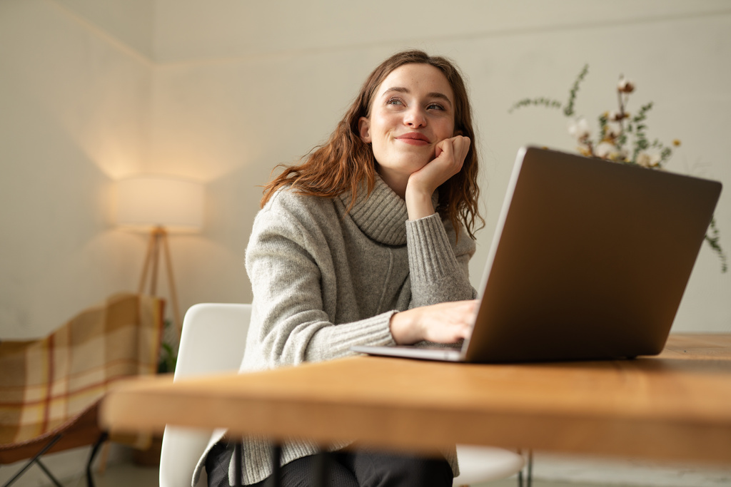 Junge Frau am Laptop, sieht glücklich aus