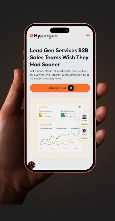 Hand holding a smartphone displaying Hypergen website with headline about B2B lead gen services and a chart comparing traditional outreach and signal-based approach.