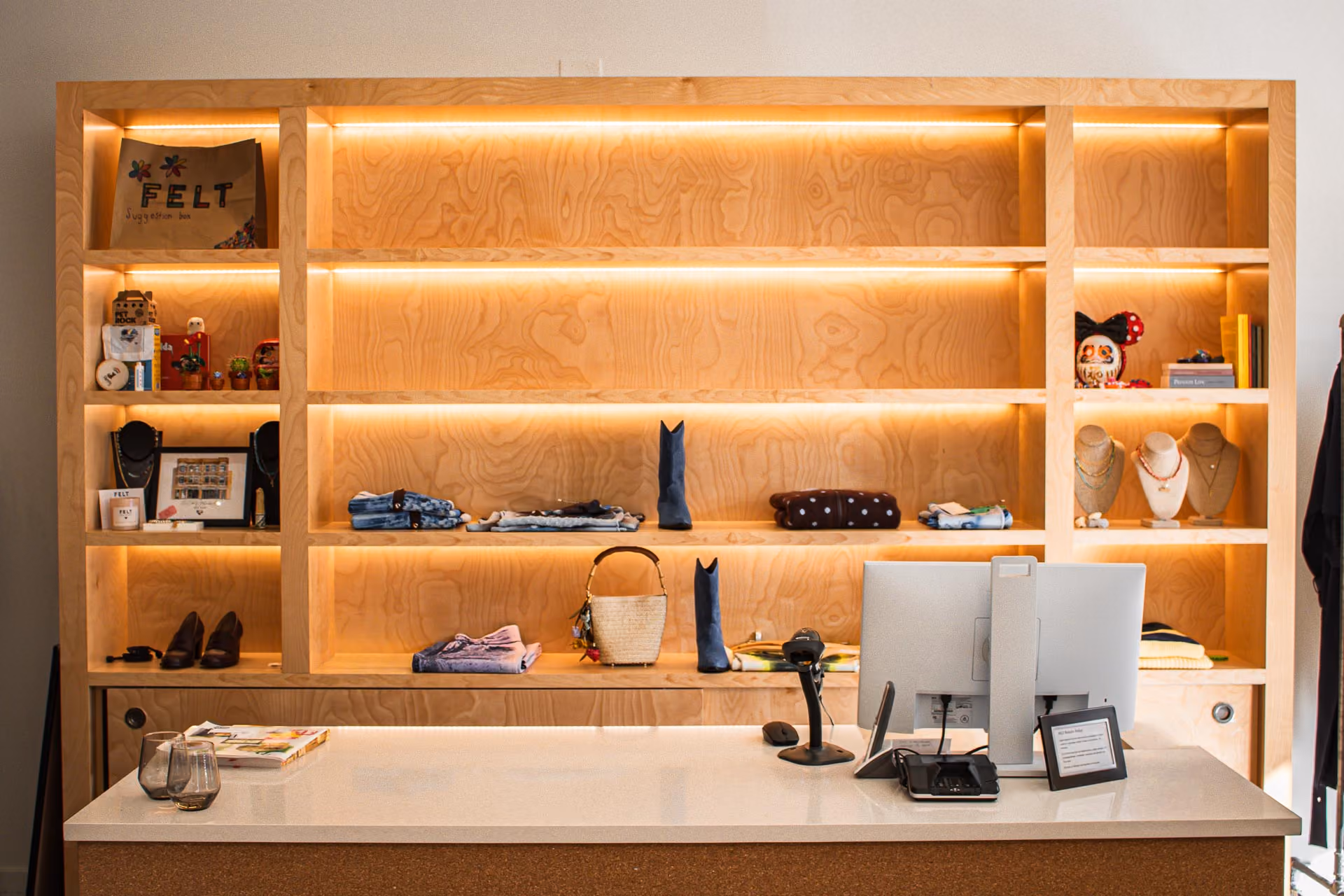 FELT Chicago checkout counter in front of lit plywood shelving with clothing and accessories