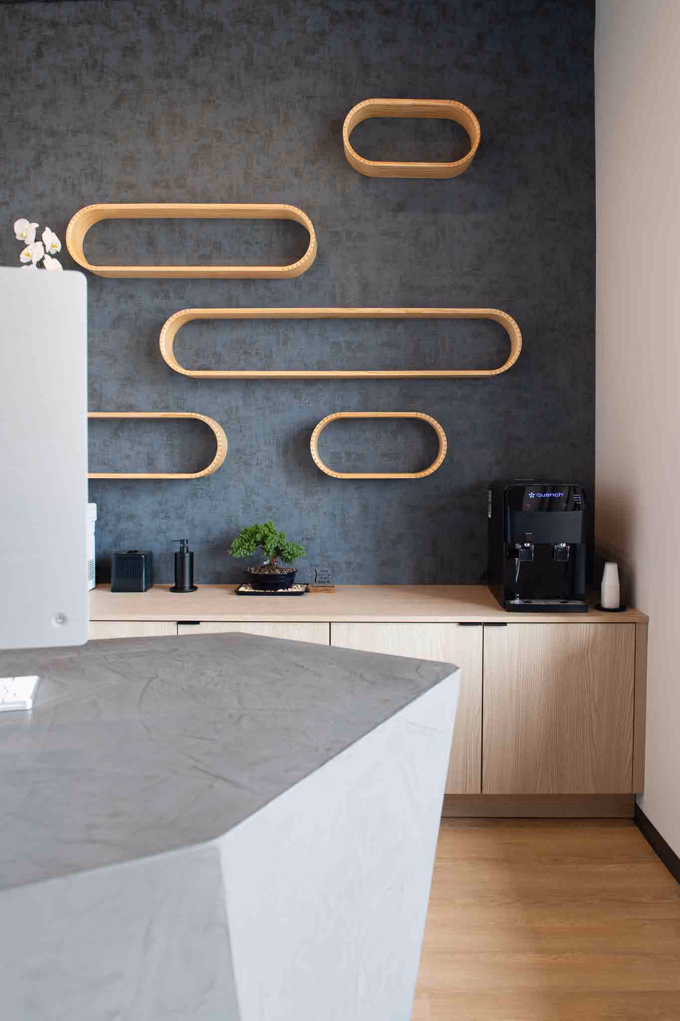Adjusted Health + Performance coffee bar with oval wood shelves on a dark textured wall