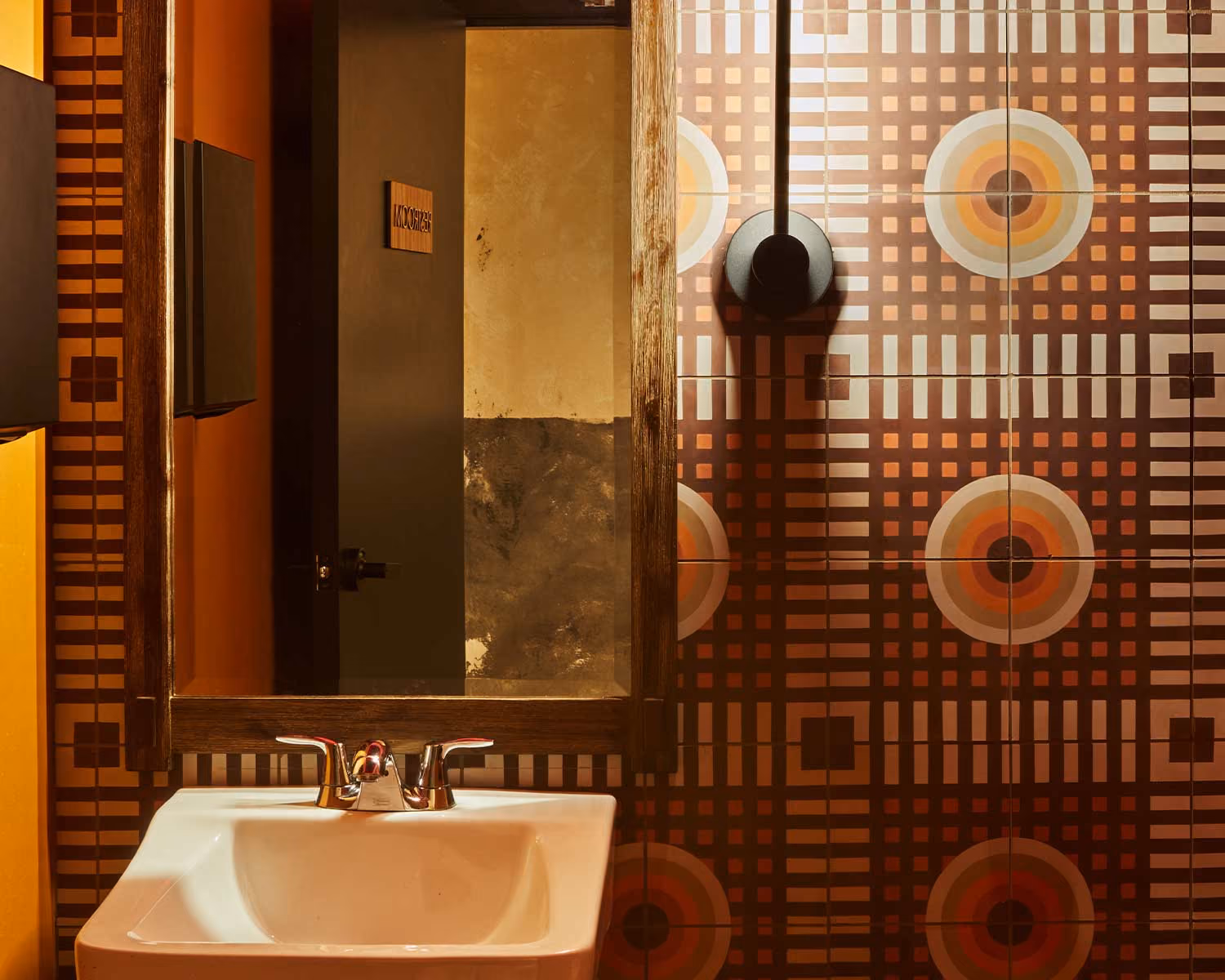 Akahoshi Ramen restroom with a patterned retro tile wall and wall-mounted sink