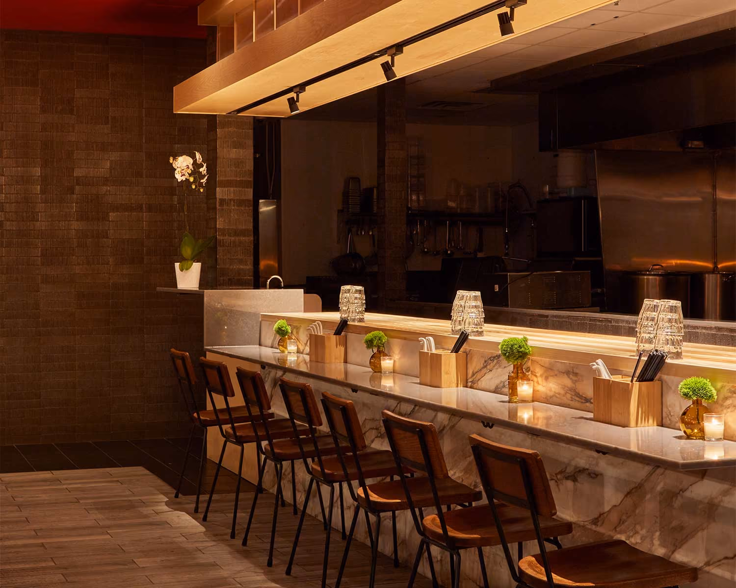Akahoshi Ramen ramen bar with high stools, a lit marble counter and the open kitchen behind