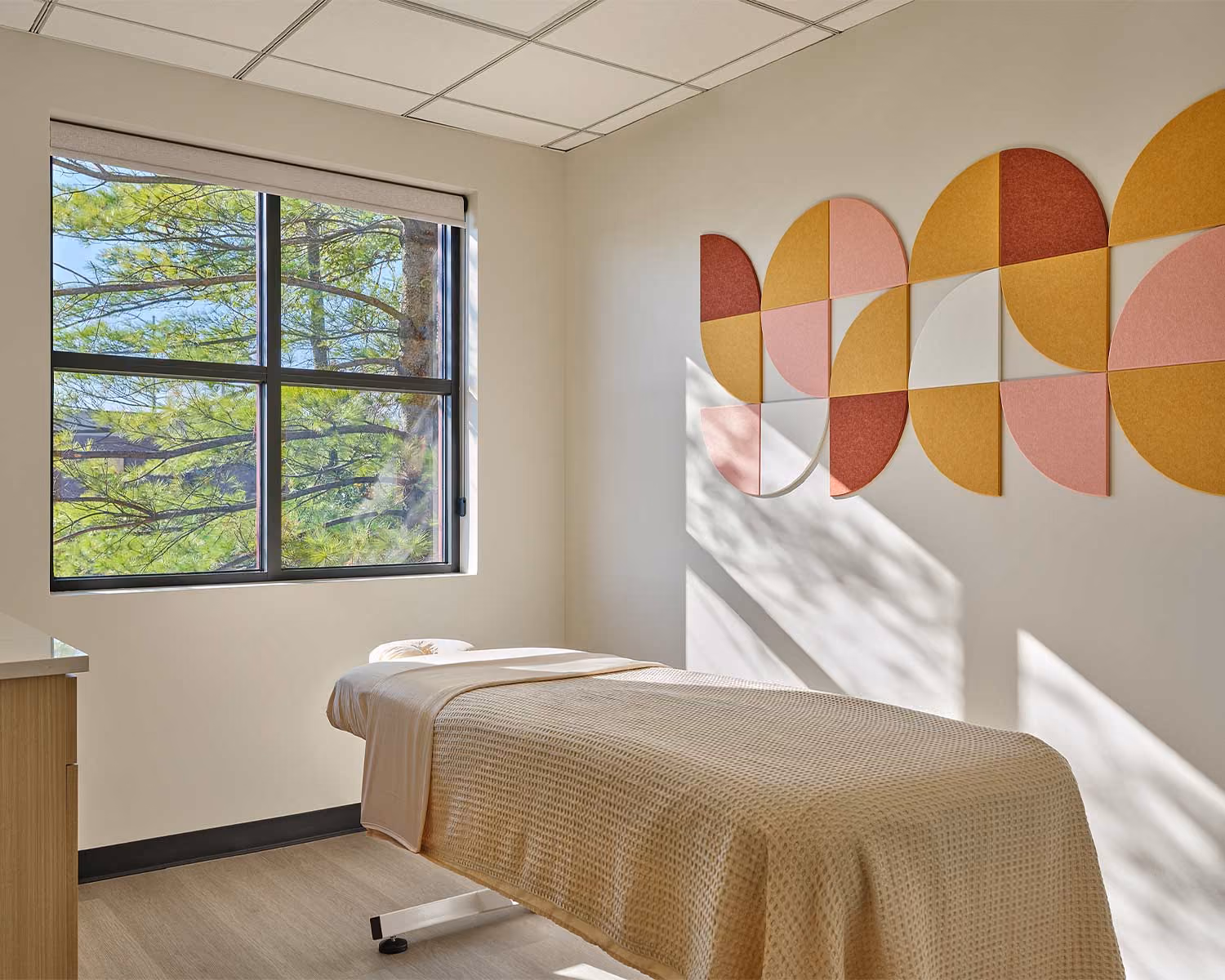 Elite Wellness treatment room with a massage table and a geometric wall mural