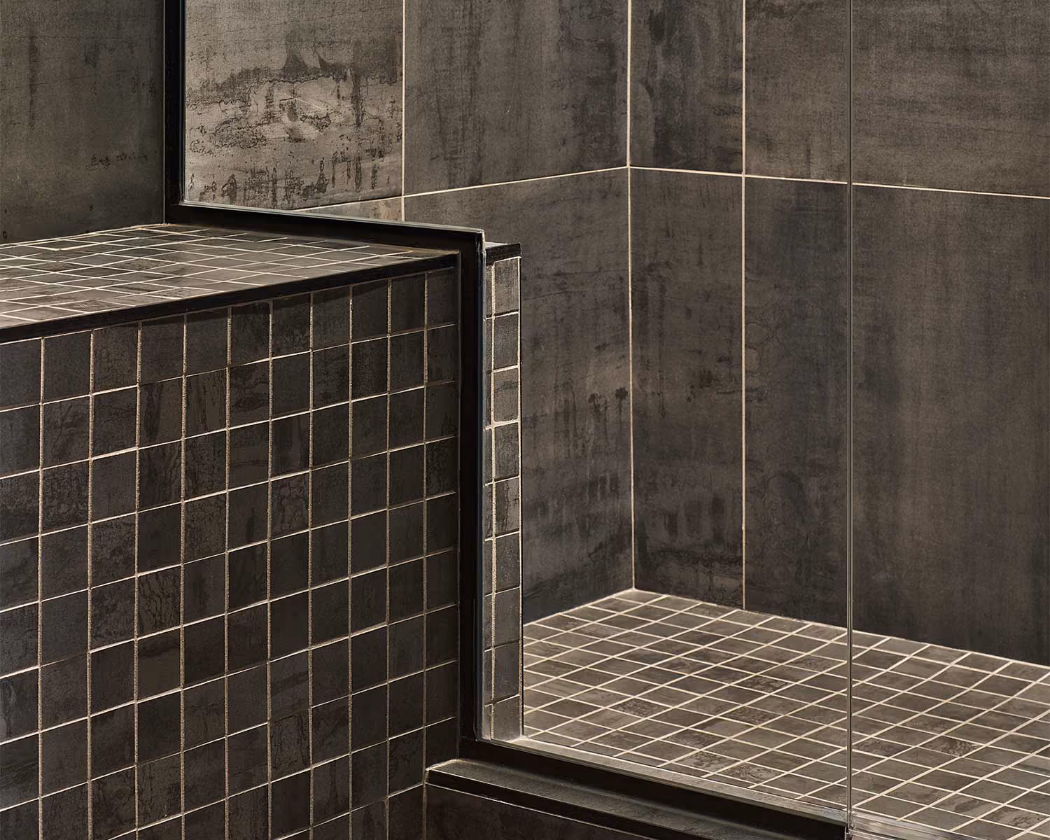 Elite Wellness shower with charcoal mosaic floor tile and large-format wall tile