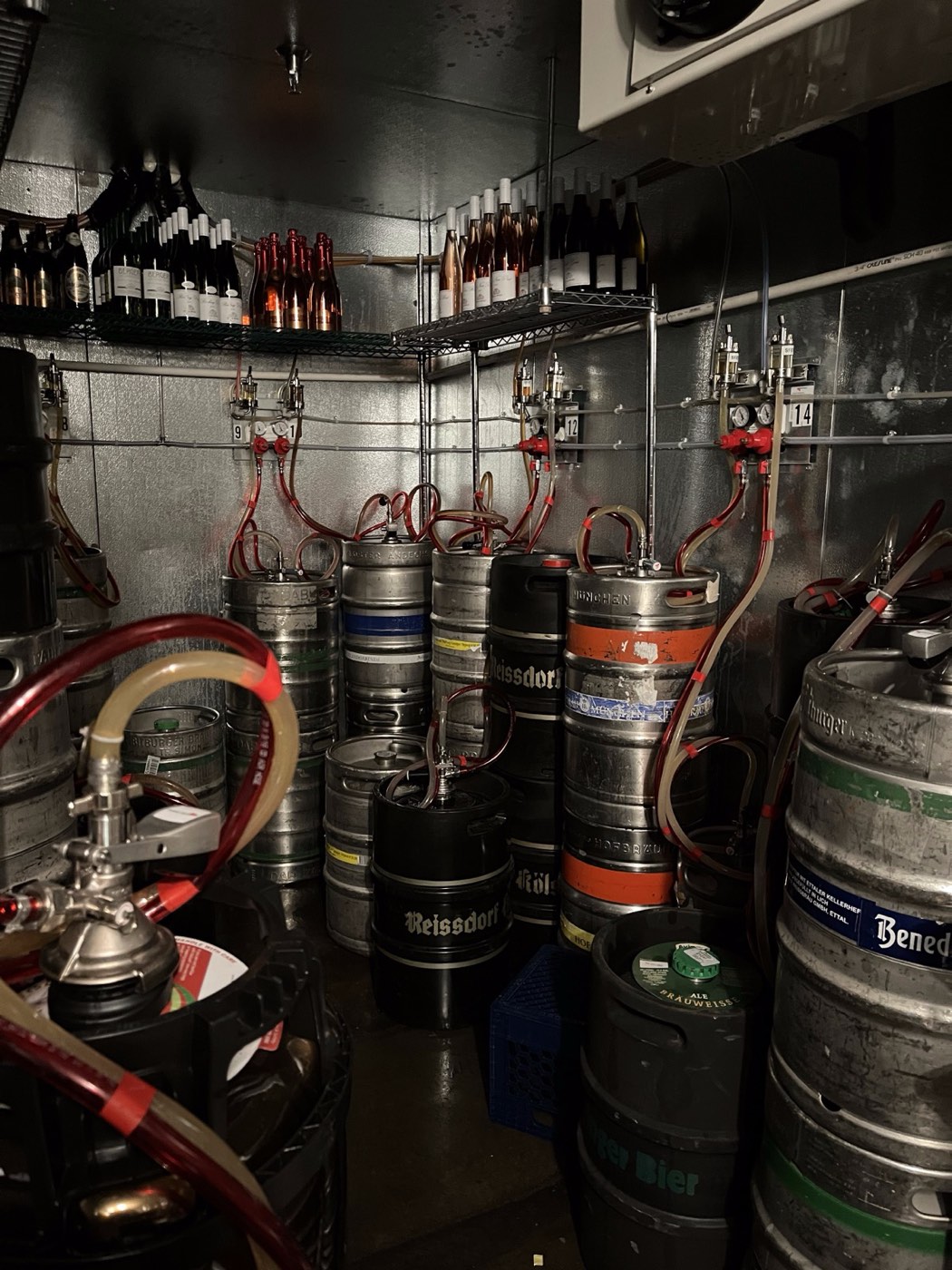 Keg room with gas lines, couplers, and connections — the part of every draft system that needs professional bi-weekly maintenance to prevent foamy beer