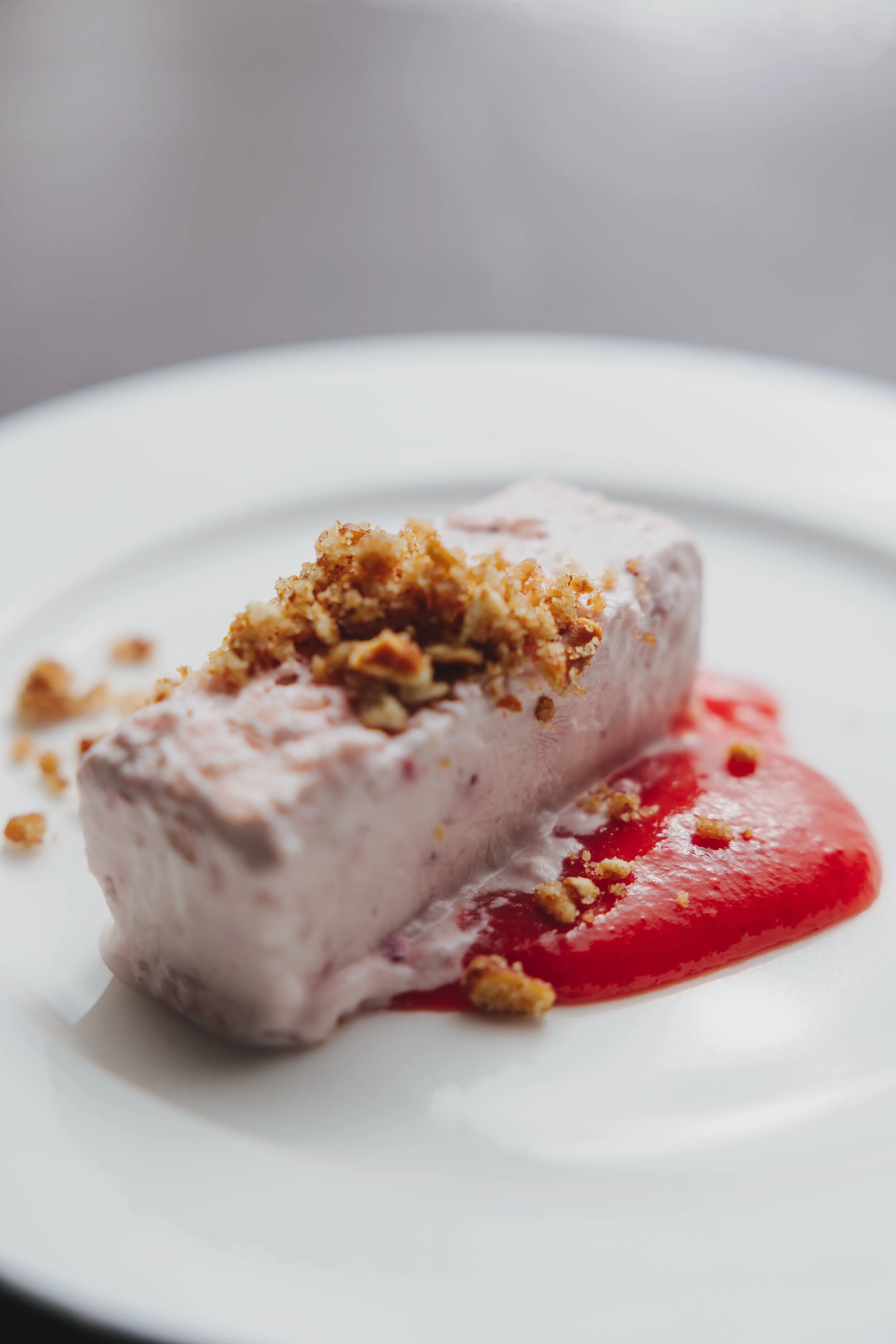Plated Magdalena’s dessert with fruit sauce and crumble