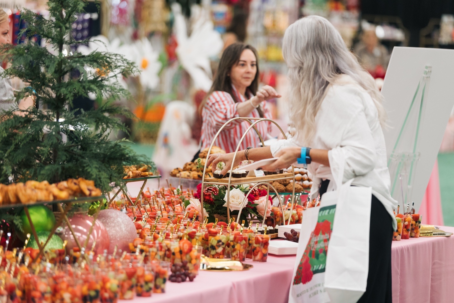 Guests choosing appetizers beside a decorated Christmas tree