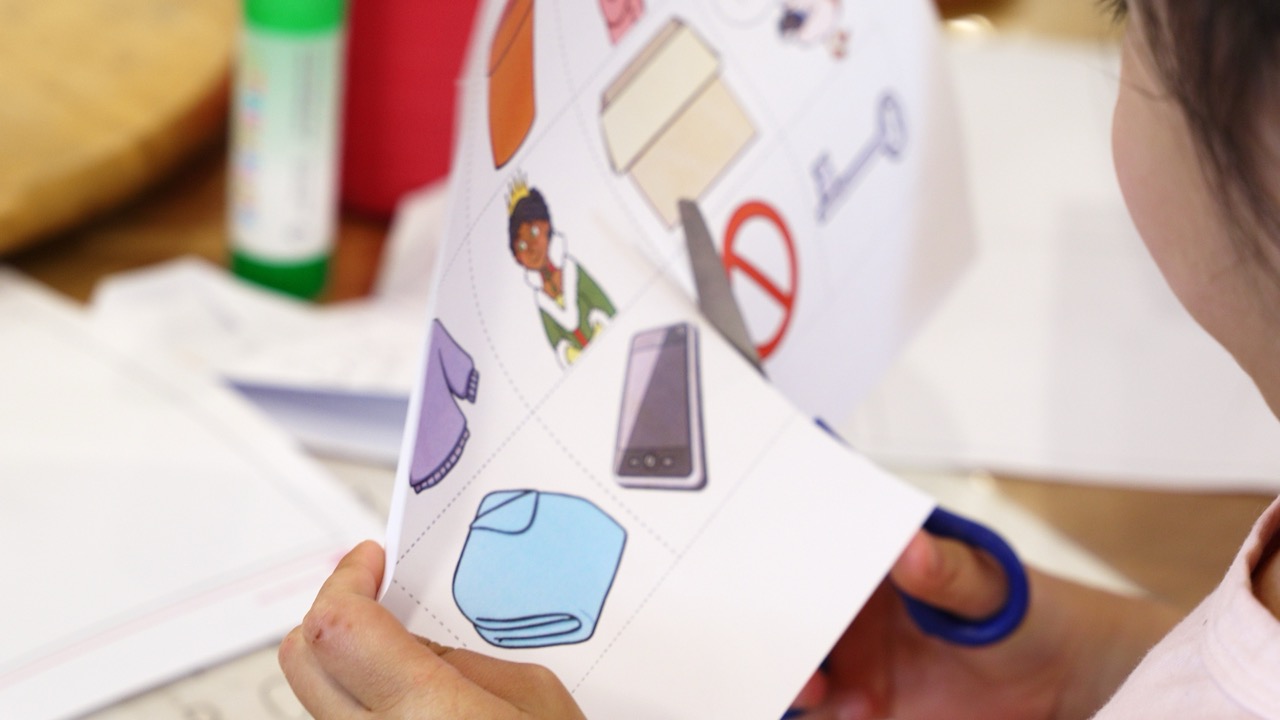 Child cutting out picture cards with scissors during a fine motor activity