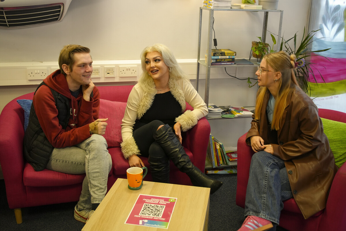 Three people sat on comfy chairs talking to each other