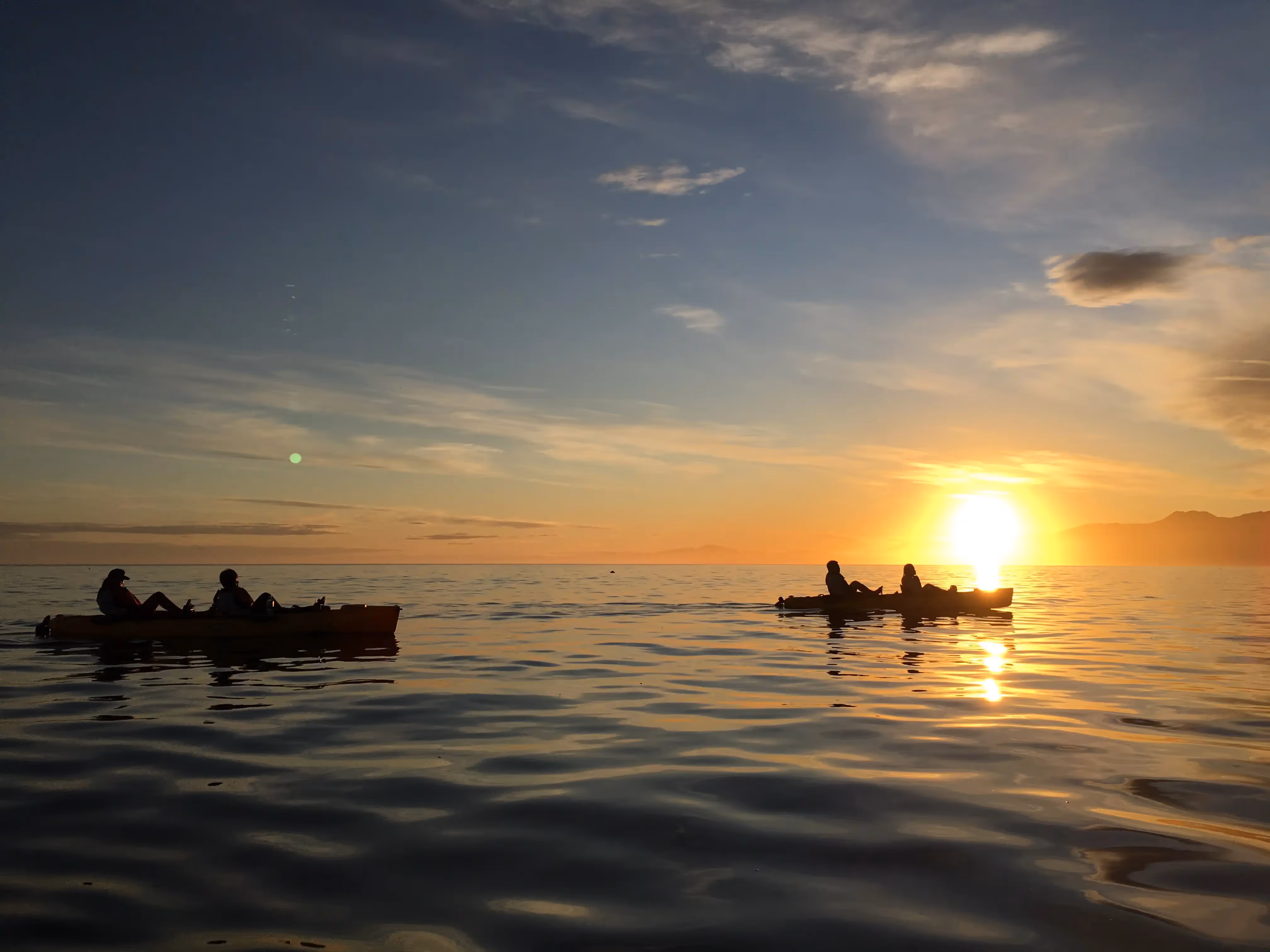 Kayaks on the water at sunset