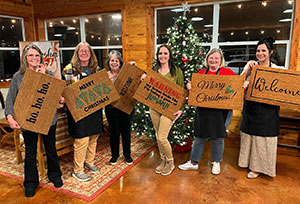 a group of people posing with custom made door mats