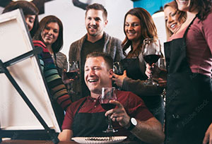 A group of friends gathered around a canvas painting