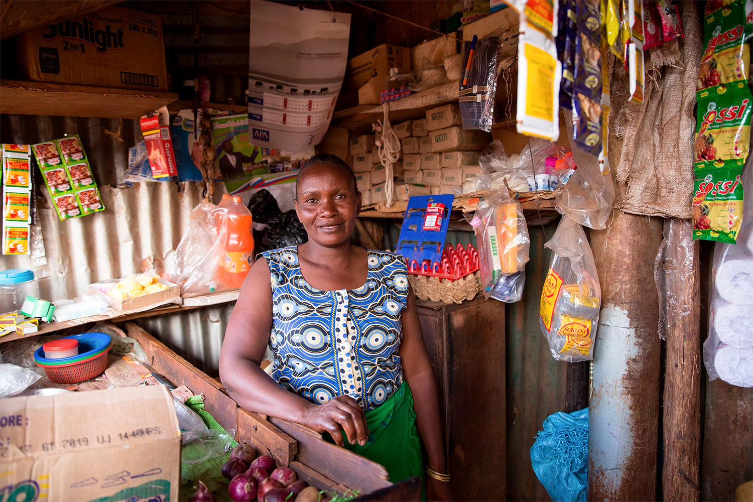 Eine Frau steht in ihrem kleinen Laden in Kibagare, der aus Krediten einer geförderten Initiative stammt.