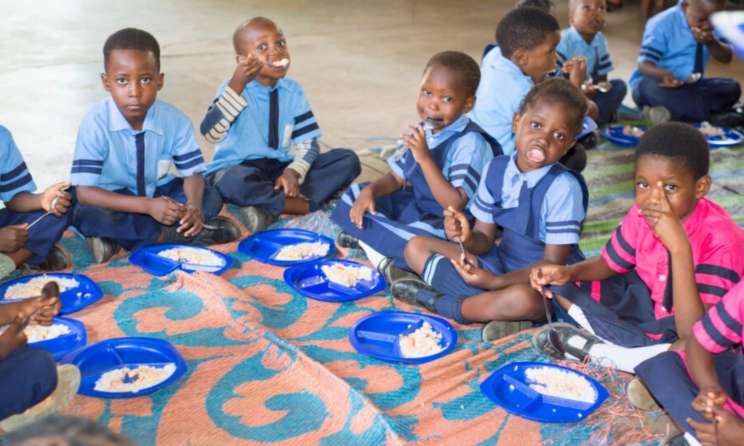 Schulkinder essen eine warme Mahlzeit in der Maria Regina Schule in Sambia.