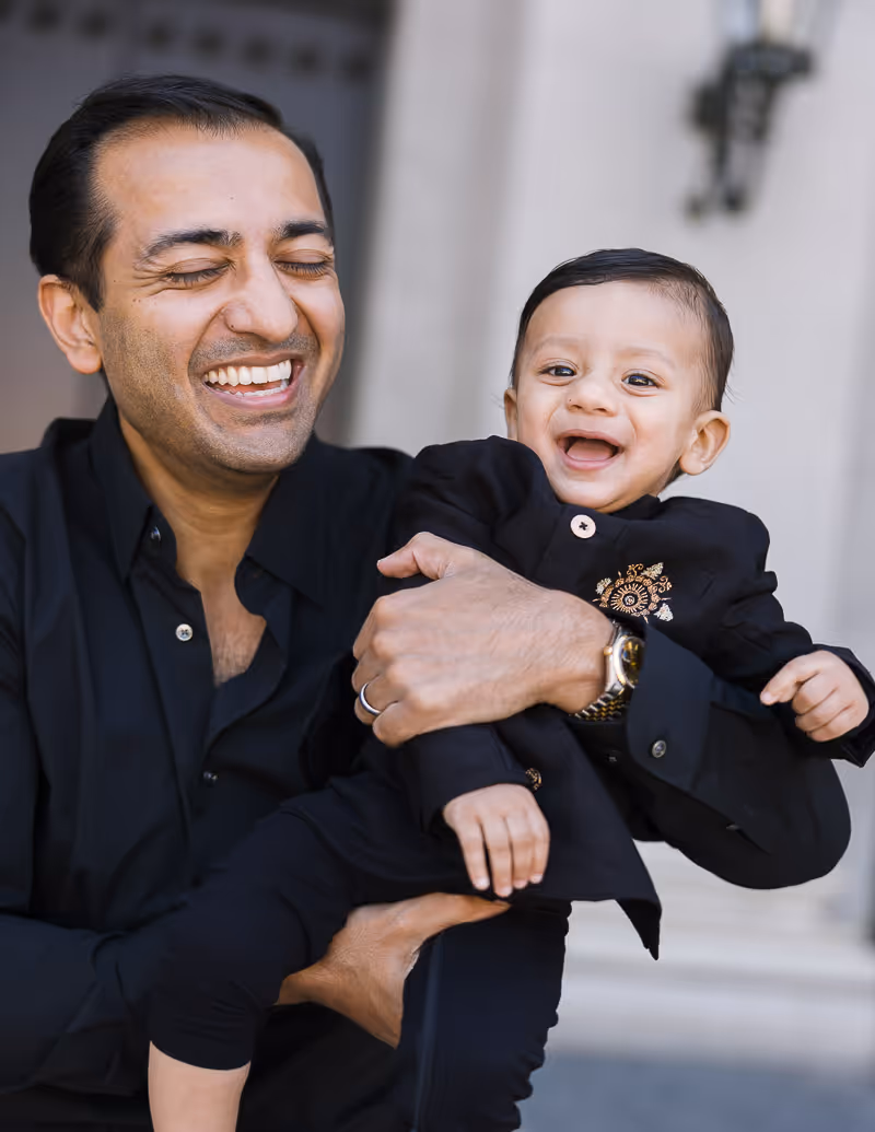 A Father holding his son laughing and smiling at Max-Joseph-Platz in Munich.
