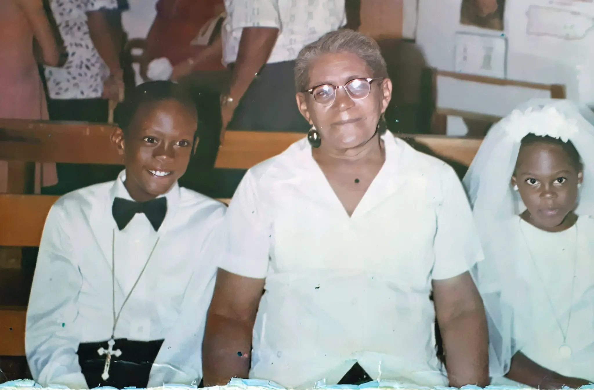 Foto de la Primera Comunión de los hermanos Julio e Hilda Rodríguez Alvarado en 1978. Están acompañados por su abuela Manuela García Prats (al centro). 
