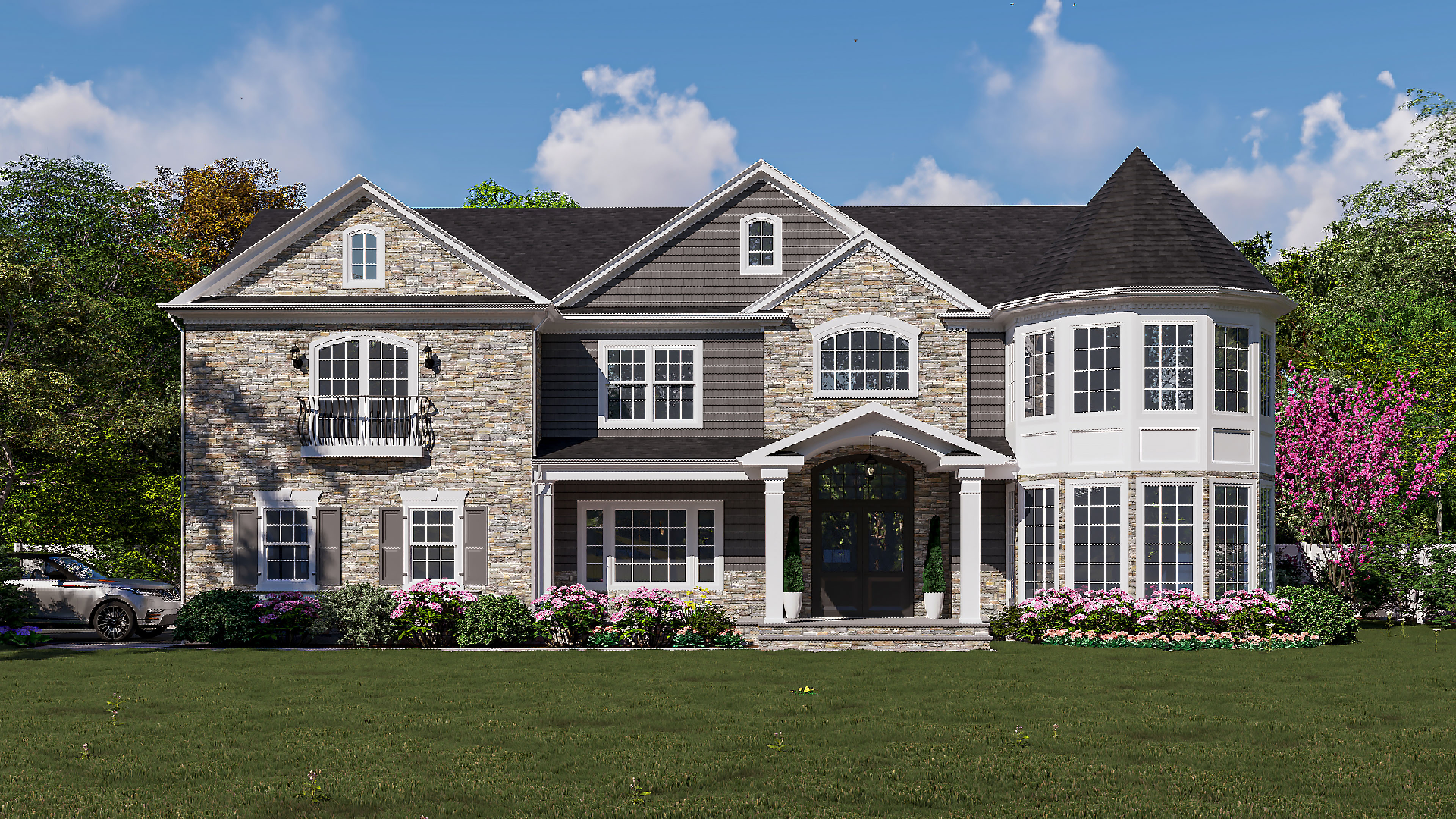 Large two-story stone and gray siding house with front porch, bay windows, flowers, and green lawn.