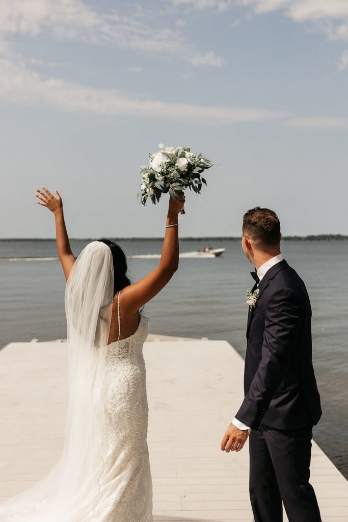 bride and groom wave to boaters at sandbanks wedding