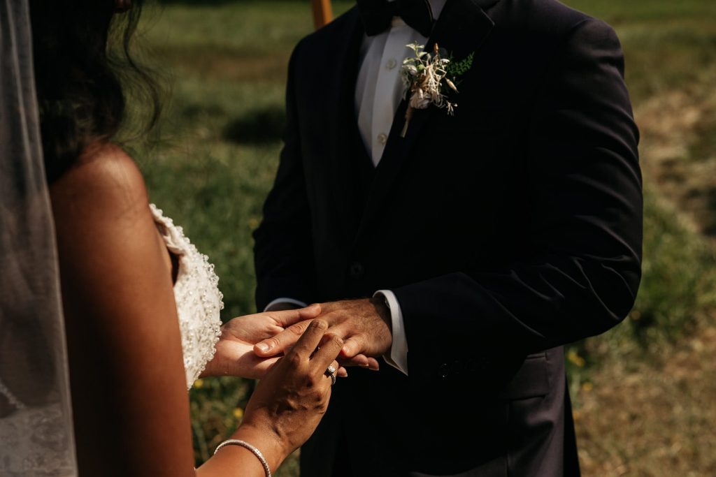 bride and groom exchange rings at backyard wedding